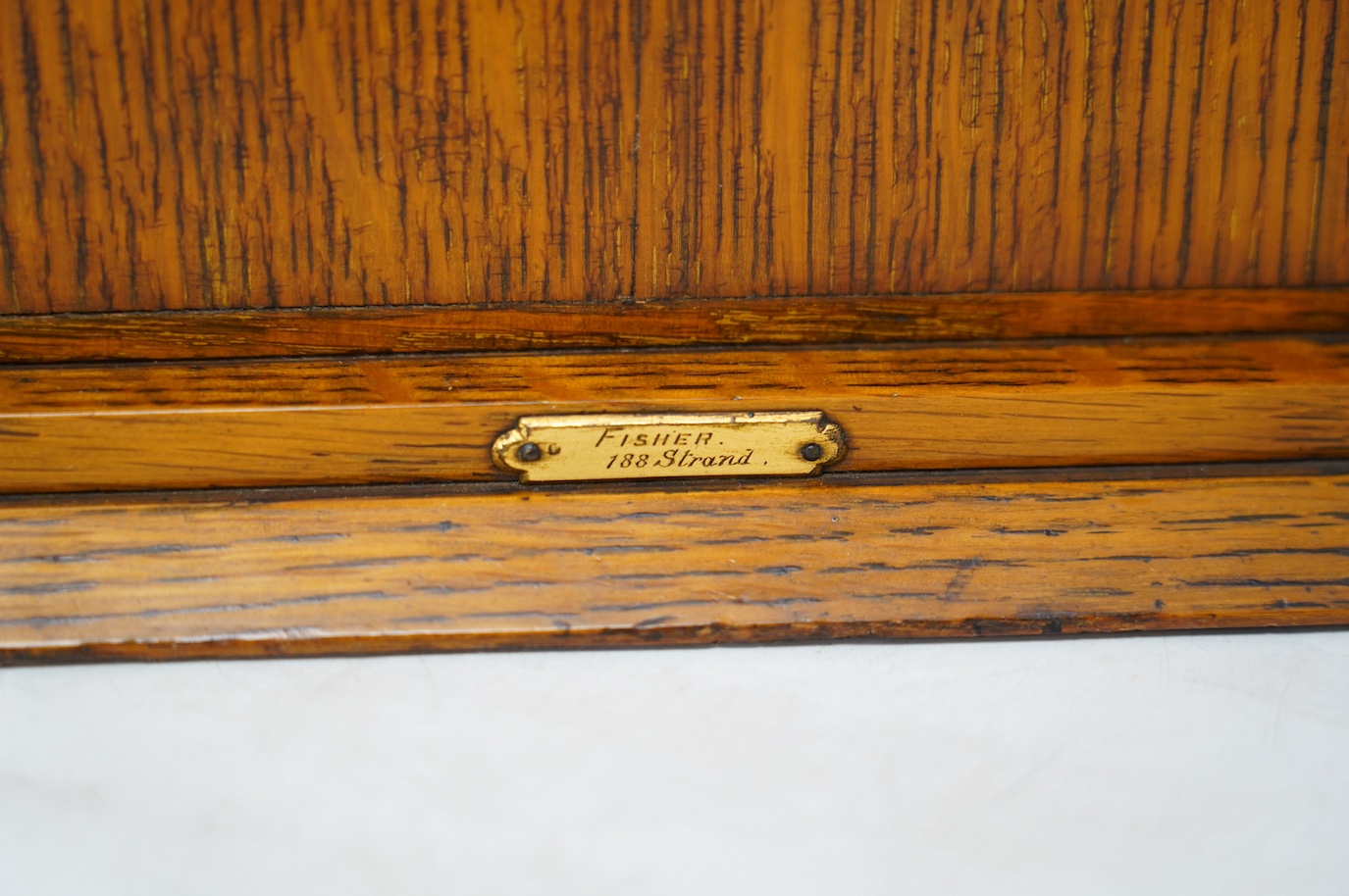 An early 20th century oak collector's cabinet, retailer Fisher, 188 Strand, 38cm wide. Condition - fair